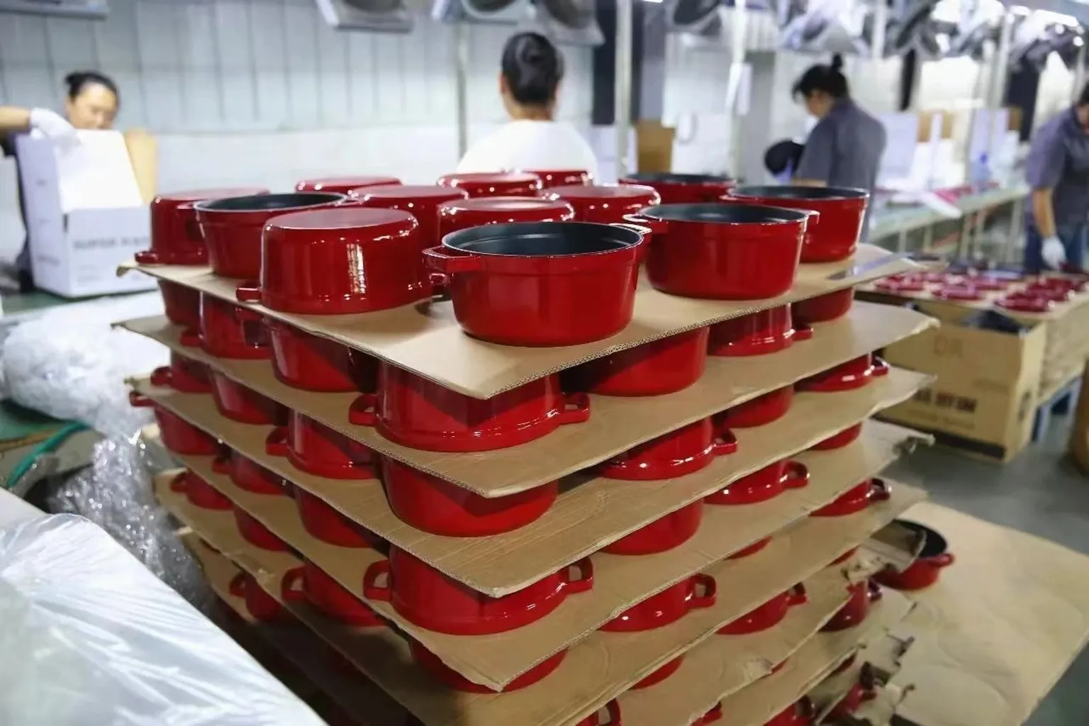 Enameled cast iron Dutch ovens lined up on the NEOO production line